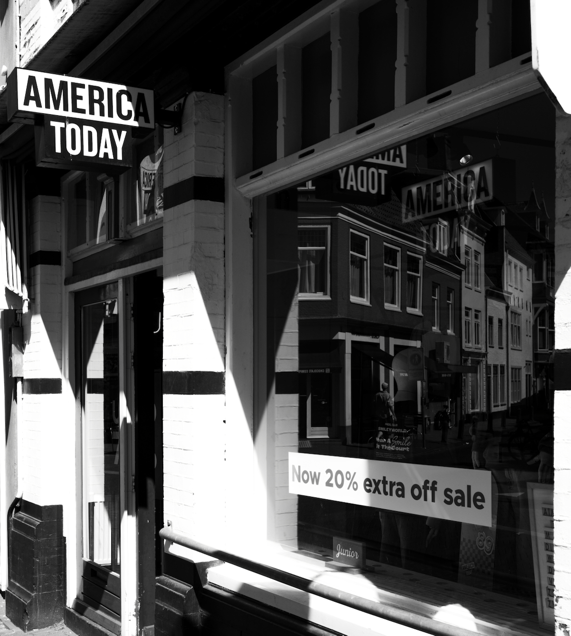 An America Today shopfront and street reflections in black and white