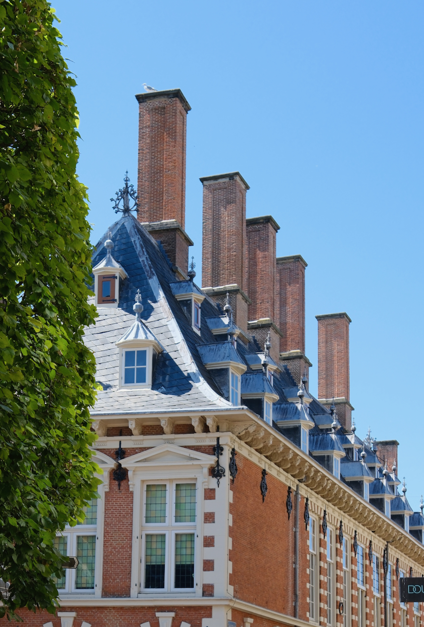 A row of tall brick chimneys above a historic Haarlem building