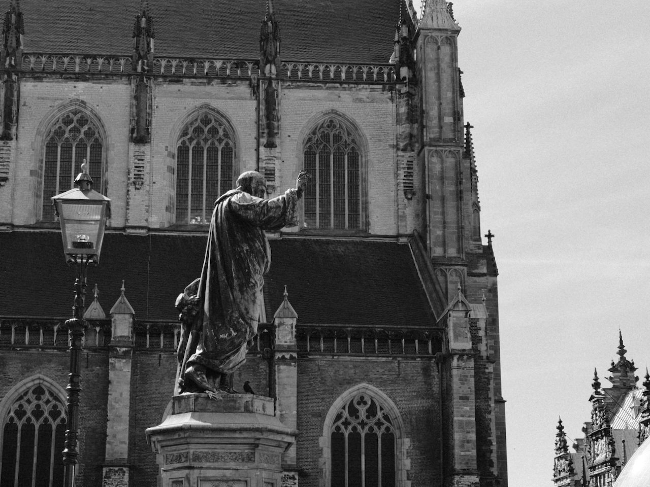 A statue and the Grote Kerk photographed in black and white