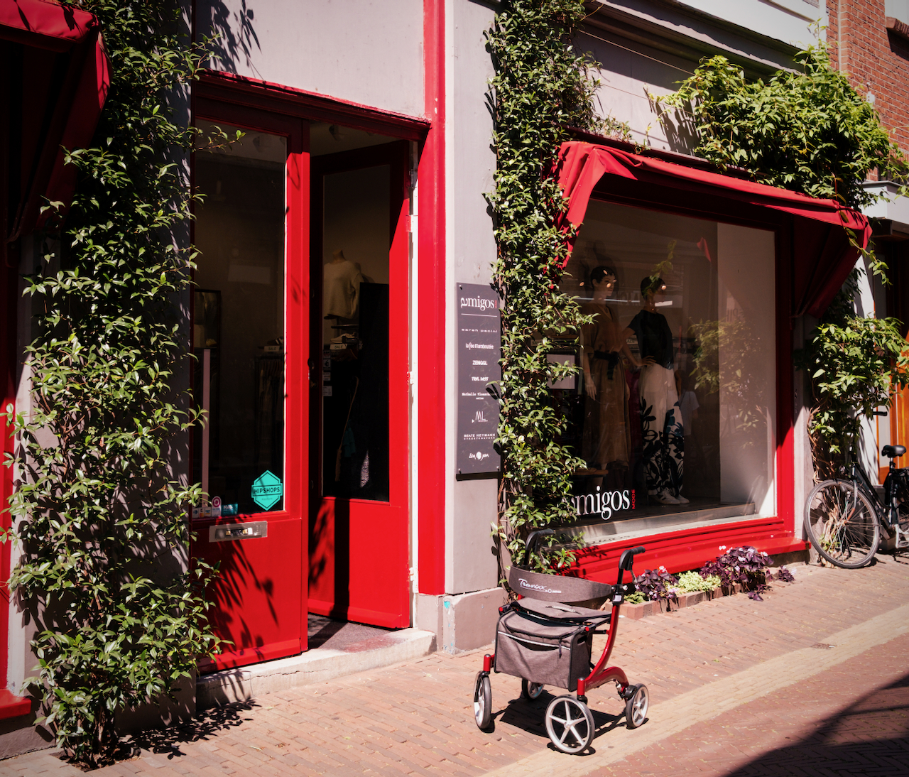 A red shopfront framed by climbing plants in Haarlem
