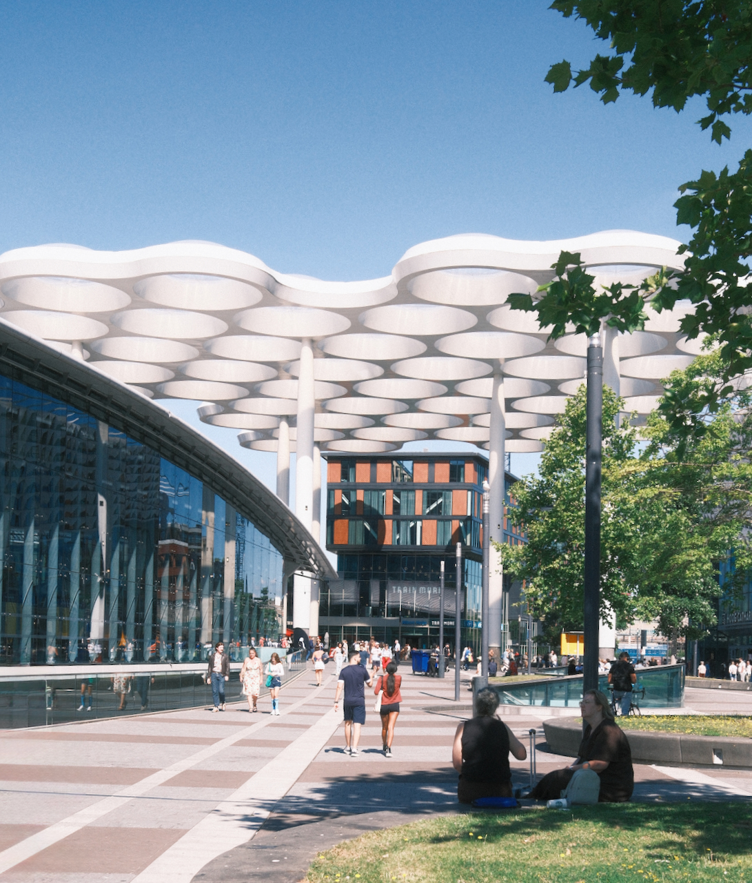 People walking beneath the white canopy outside Utrecht Centraal
