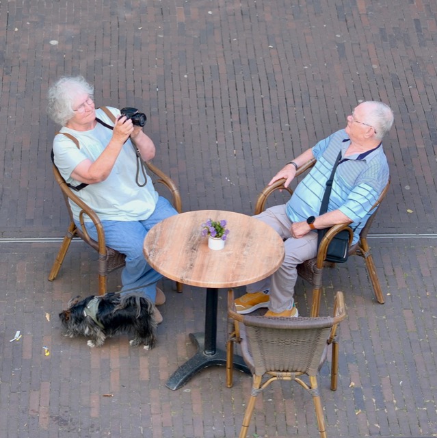 A couple and their dog at an outdoor cafe table in Zaandam