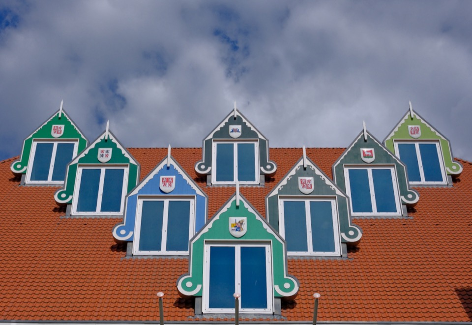 A row of colorful Zaanse gables beneath a dramatic summer sky